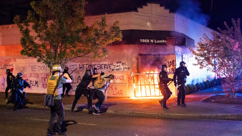 (Editor's note: Part of this photo has been blurred because of profanity.) PORTLAND, OR - AUGUST 29: Portland police disperse a crowd after protesters set fire to the Portland Police Association (PPA) building early in the morning on August 29, 2020 in Portland, Oregon. The PPA, a headquarters for the Portland police union, has been a regular target during the 93 days of protests in Portland. (Photo by Nathan Howard/Getty Images)