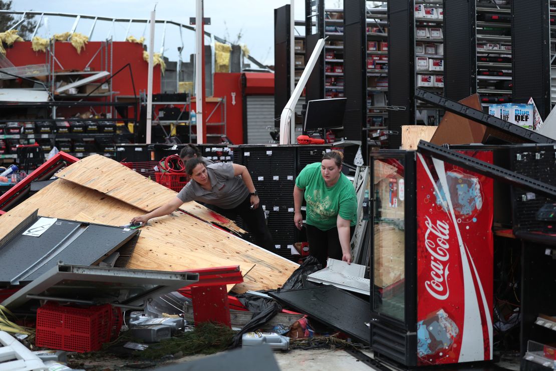 Rachel Ellis (left) and J'Nay Fitch salvage items from the AutoZone store where they worked in Lake Charles, Louisiana. Hurricane Laura ripped the roof off the store.