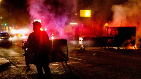 People protesting police brutality spray graffiti and start fires at the Portland Police Union on Friday.