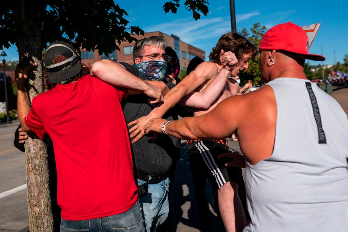 A Black Lives Matter protester scuffles with attendees of a pro-Trump rally during an event held to show support for the President on Saturday in Clackamas, Oregon.