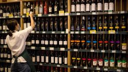 An employee works as Australian-made wine (on display shelves on R) are seen for sale at a store in Beijing on August 18, 2020. - China on August 18 ramped up tensions with Australia after it launched a probe into wine imports from the country, the latest salvo in an increasingly bitter row between the trade partners. (Photo by NOEL CELIS / AFP) (Photo by NOEL CELIS/AFP via Getty Images)