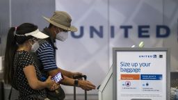 A traveler wearing a protective mask uses a kiosk to check-in at a United Airlines Holdings Inc. counter at San Francisco International Airport (SFO) in San Francisco, California, U.S., on Tuesday, Aug. 11, 2020. Travel stocks, including airlines, hotels and cruise-line operators, gained some more premarket Tuesday, building on Mondays rally, when Transportation Security Administration data showed airline passenger numbers were improving. Photographer: David Paul Morris/Bloomberg via Getty Images