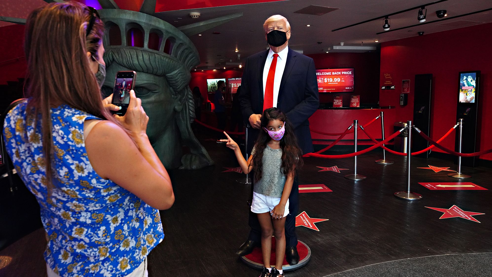 A child is photographed in front of a Donald Trump wax figure at Madame Tussauds New York on August 27. 
