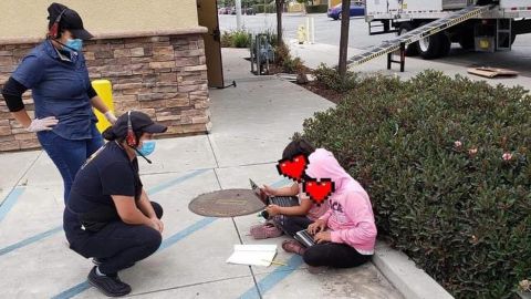 Two children outside a Taco Bell in Salinas, California using the free WiFi to do schoolwork. The poster of this image obscured the faces of these children pictured.