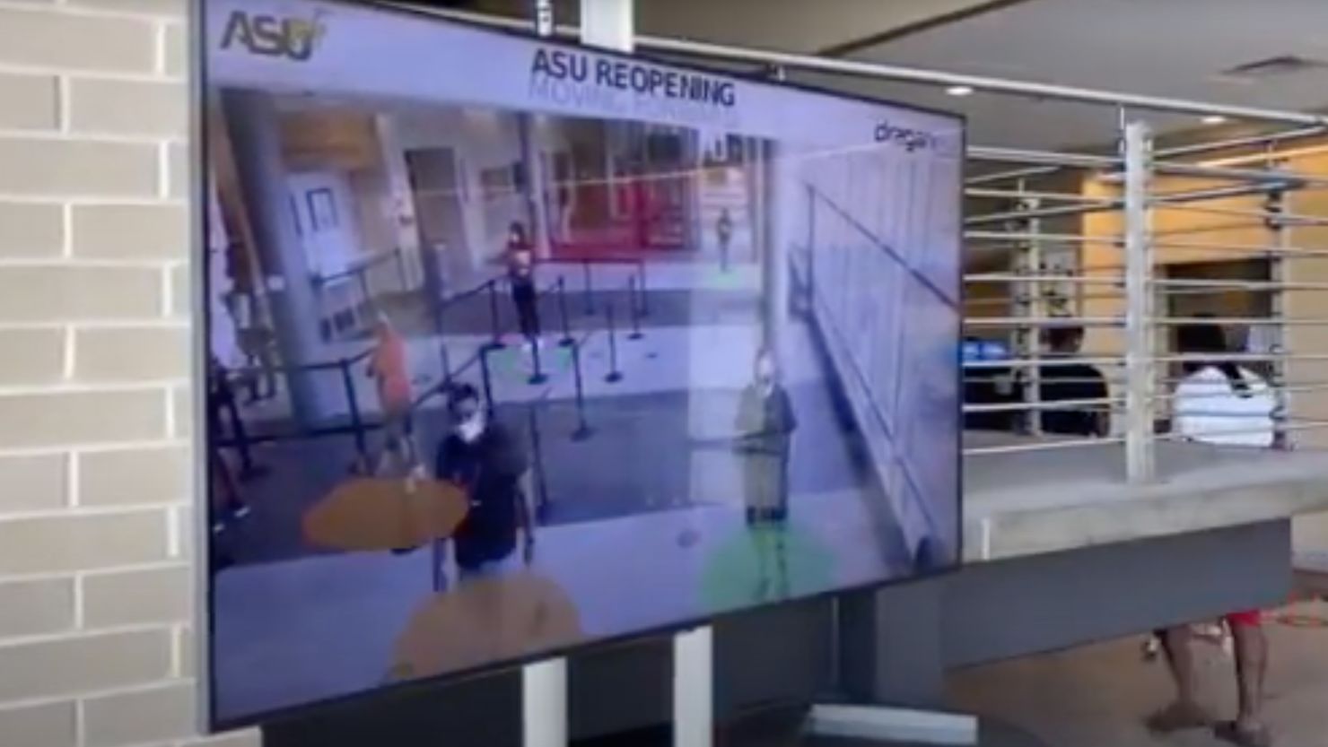 Screening stations made by Draganfly show a live video feed of people walking nearby and indicate whether they are social distancing. Red circles mark those who are less than 6 feet from another person.