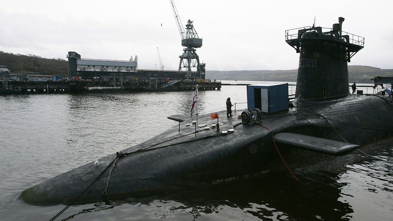 A Royal Marine soldier is seen standing guard on submarine HMS Vanguard moored at the Faslane naval base near Glasgow, Scotland in this December 4, 2006 file photograph. Two nuclear-armed submarines, one British and one French, collided underwater while on separate patrols in the Atlantic Ocean, the head of the Royal Navy said on February 16, 2009.  REUTERS/David Moir/Files  (BRITAIN)