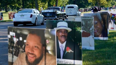 A procession of vehicles drive past photos of Detroit victims of Covid-19 on Monday.