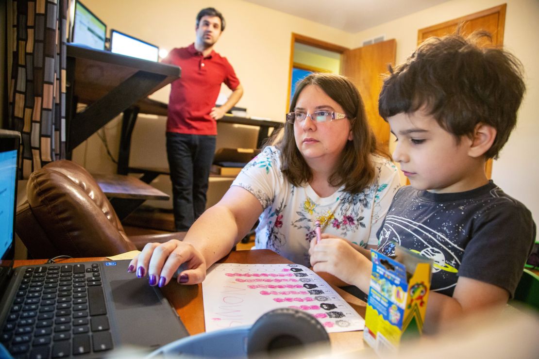 Kara Vaughn helps her son Simon, a kindergartner, get set up for class on Zoom at their home in Urbandale, Iowa, on July 30, 2020. 