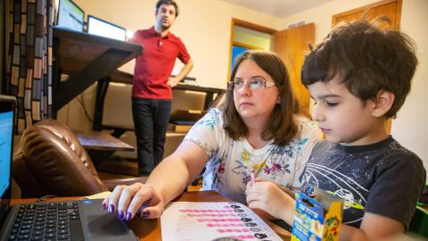 Kara Vaughn helps her son Simon, a kindergartner, get set up for class on Zoom at their home in Urbandale, Iowa, on July 30, 2020.