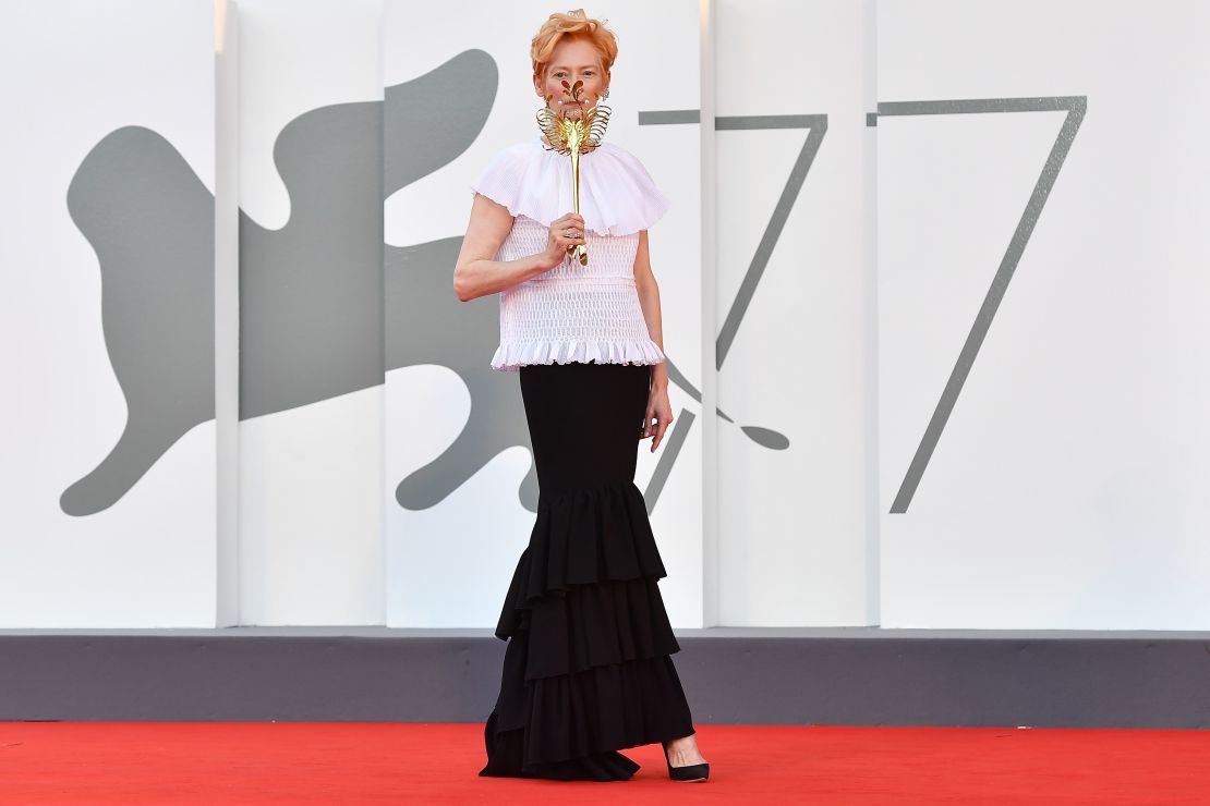 Tilda Swinton arrives for the festival's opening ceremony and first screening holding a custom sea creature-inspired mask by artist James Merry.
