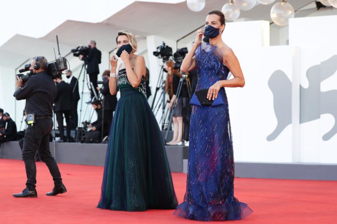 Actors Anna Foglietta and Roberta Armani in Giorgio Armani Haute Couture arrive for the opening ceremony in cloth masks matching their dark green and vivid blue looks. Masks this year are a common sight on the red carpet.