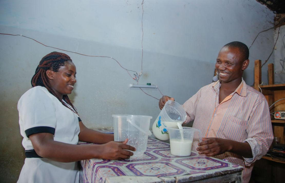 Shopkeeper Kioko Mwange, right, from eastern Kenya, serves fresh milk to a customer. 