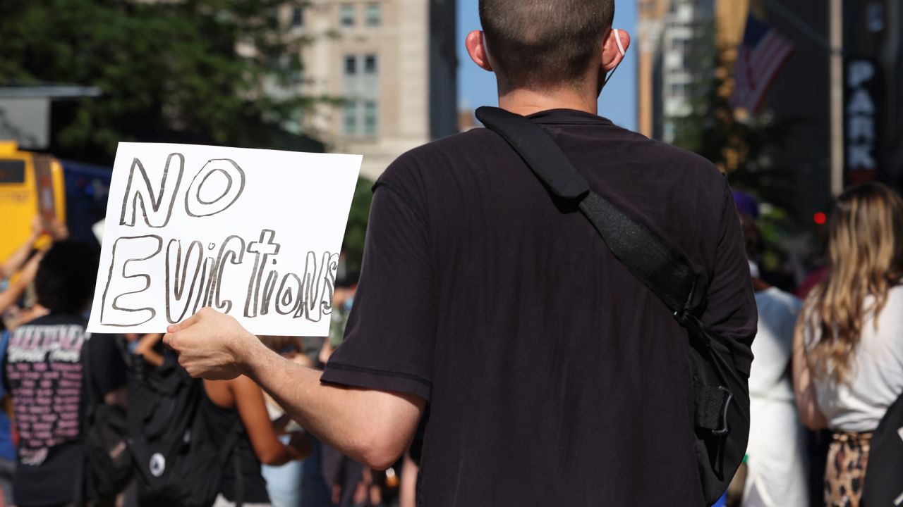 A demonstrator holds up a sign as he listens to speakers during a "Resist Evictions" rally on August 10, 2020 in New York City.