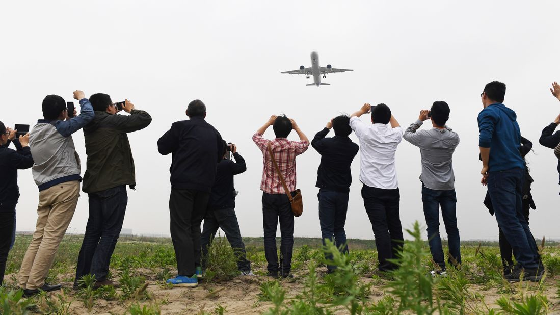 <strong>Maiden flight: </strong>Spectators watch the Comac C919 come in to land on its maiden flight at Shanghai's Pudong airport on May 5, 2017. 