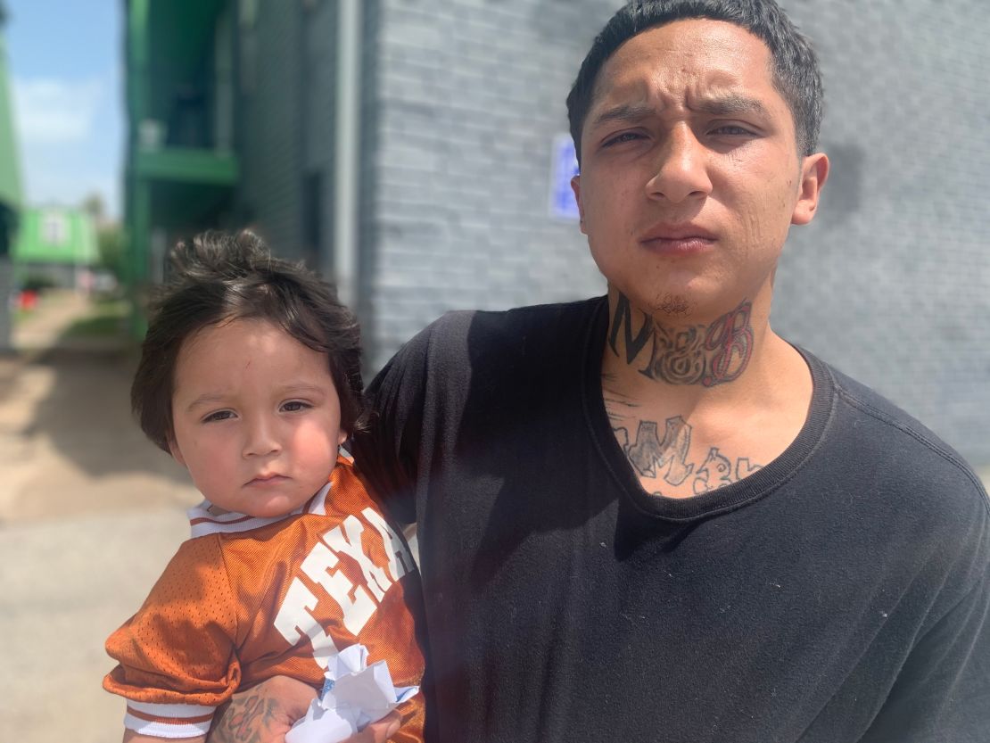 Israel Rodriguez, 24, holds his 20-month-old son, also named Israel