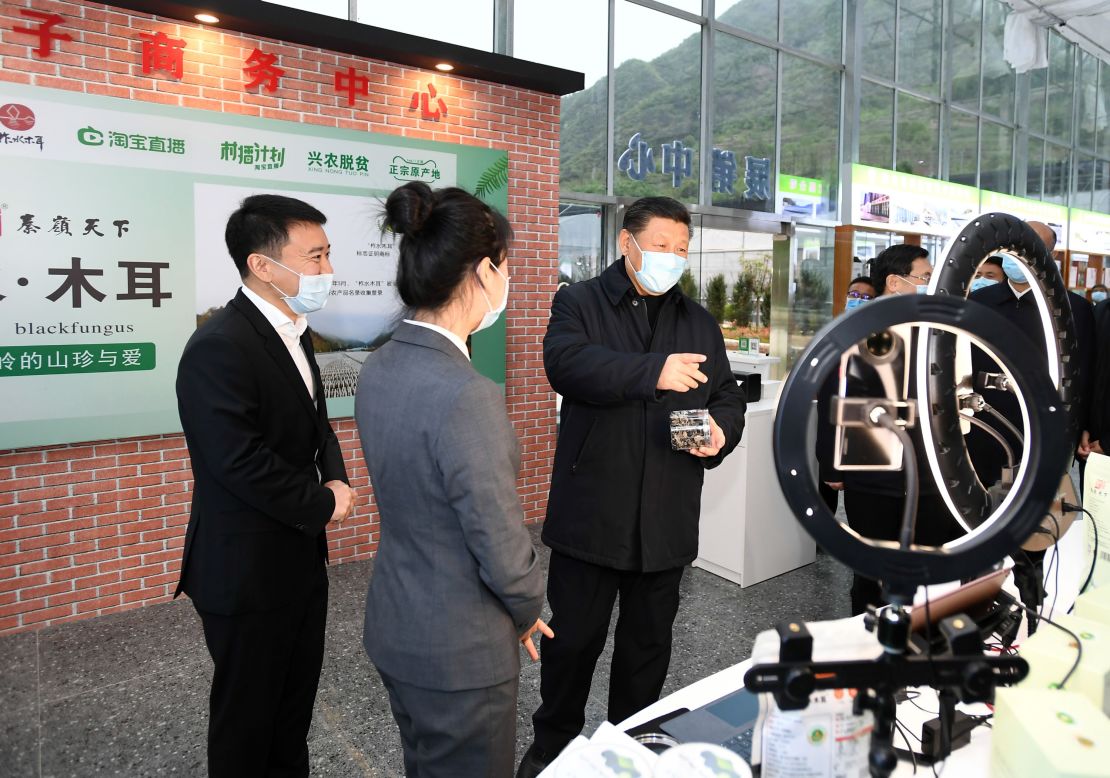 Chinese President Xi Jinping talking to a live-streaming host during the set-up of a live shopping session to market local produce in Jinmi, Zhashui county, northwest China's Shaanxi province in April.