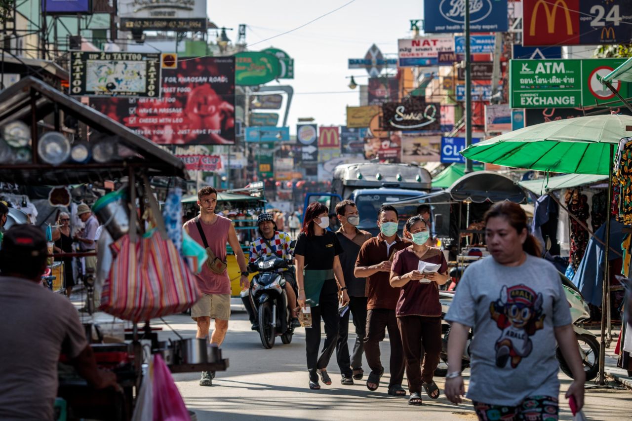People donning facemasks walk along Khao San Road, a popular area for tourists in Bangkok, Thailand on March 6, 2020.