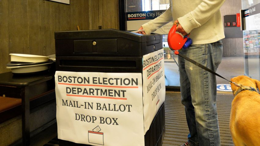 A man with his dog drops off his mail-in ballot at Boston City Hall during the Massachusetts State Primary on September 1, 2020 in Boston, Massachusetts. (Photo by Joseph Prezioso / AFP) (Photo by JOSEPH PREZIOSO/AFP via Getty Images)