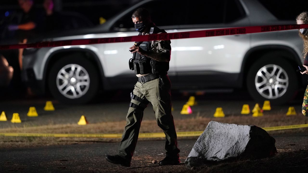 Police walk past evidence markers at the scene where a man suspected of fatally shooting a supporter of a right-wing group in Portland, Ore., last week was killed as investigators moved in to arrest him in Lacey, Wash., Thursday, Sept. 3, 2020. Michael Reinoehl, 48, was killed as a federal task force attempted to apprehend him, a senior Justice Department official said. Reinoehl was the prime suspect in the killing of 39-year-old Aaron "Jay" Danielson, who was shot in the chest Saturday night, the official said. (AP Photo/Ted Warren)
