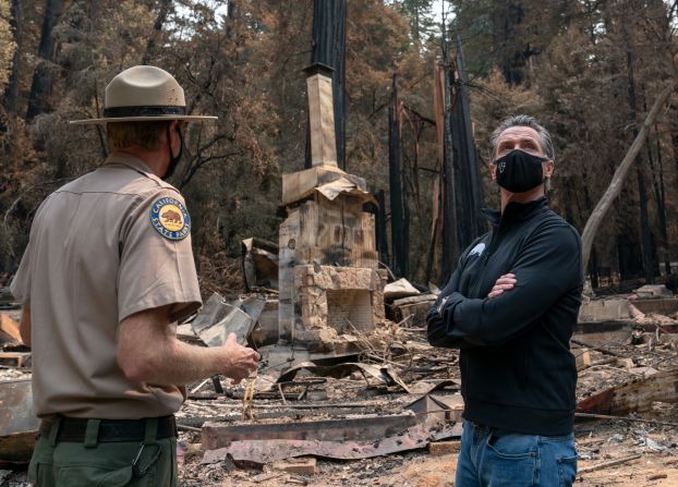 California Gov. Gavin Newsom, right, listens as Santa Cruz State Park Superintendent Chris Spohrer talks about the fire damage to the Big Basin Redwoods State Park on September 1, 2020.