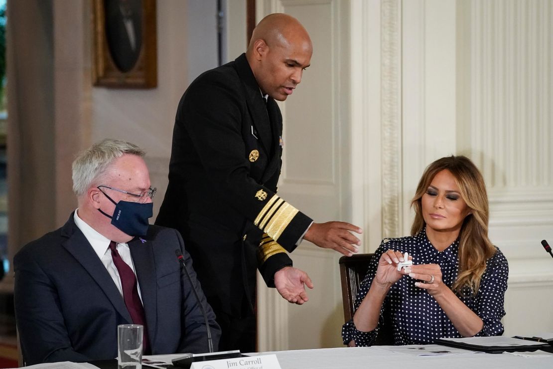 Director of National Drug Control Policy James Carroll looks on as U.S. Surgeon General Jerome Adams shows First Lady Melania Trump a Naloxone nasal spray, which helps reverse opioid overdoses, during an event to mark National Alcohol and Drug Addiction Recovery Month in the East Room of the White House on September 3, 2020 in Washington, DC. The First Lady hosted a round table event with people who are recovering from substance use and mental health issues.