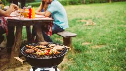 People gather in a park for a barbeque 