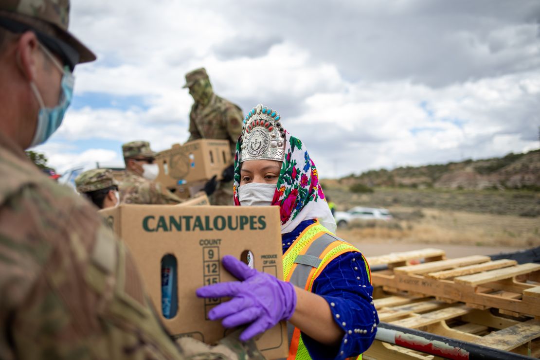 Miss Navajo Nation Shaandiin Parrish grabs a box filled with food and other supplies to distribute to Navajo families.