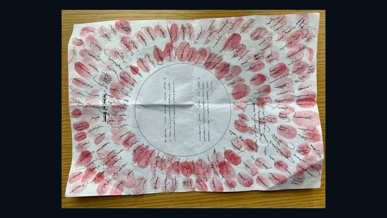 A petition signed by residents with their fingerprints in red ink stamped over signatures.
