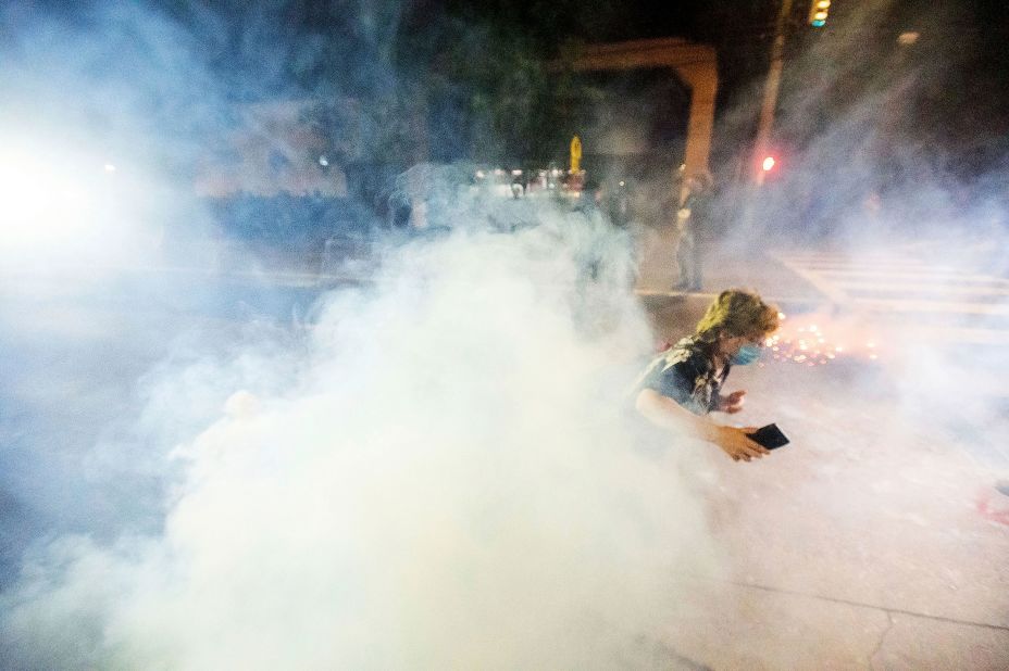 A protester runs away from chemical irritants fired by police to disperse protesters outside the Portland Police Association building on September 5.