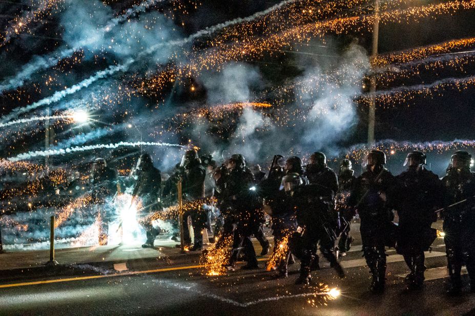 Oregon state troopers and Portland police advance through tear gas and fireworks while dispersing a protest on September 5.