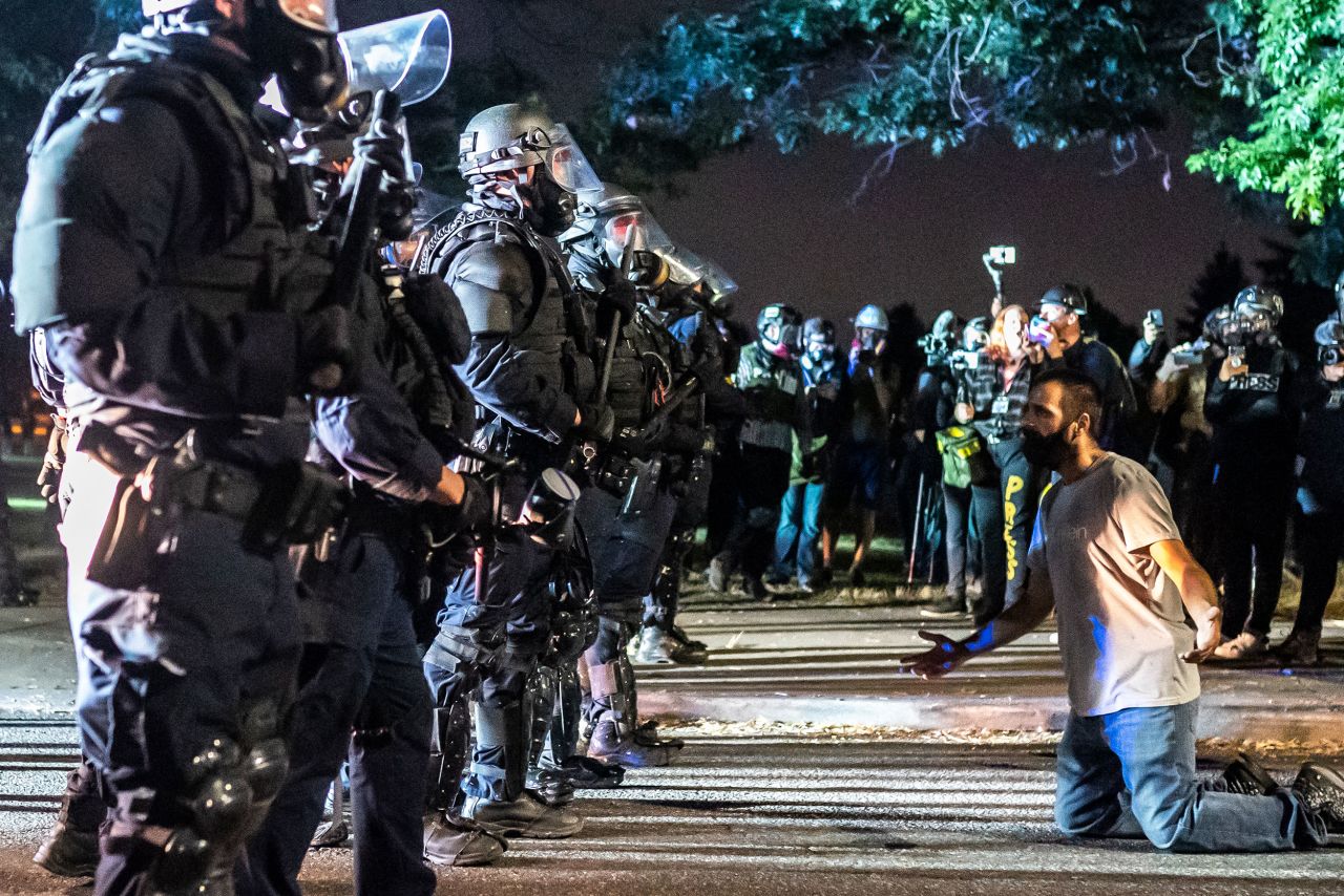A protester holds his hands out in front of a police line during a protest on September 5.