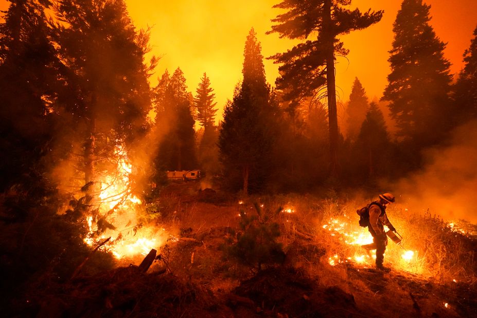 A firefighter sets a controlled burn with a drip torch while fighting the Creek Fire in Shaver Lake.