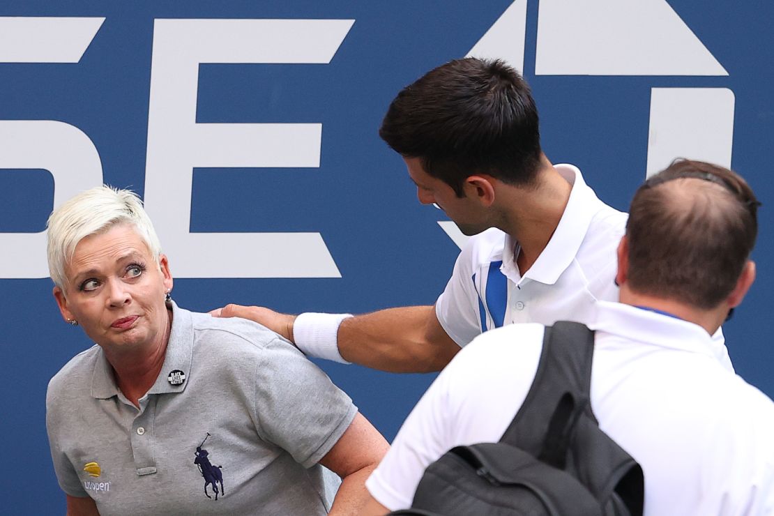 Djokovic tends to a line judge who was hit with the ball during his men's singles match against Pablo Carreno Busta at the US Open