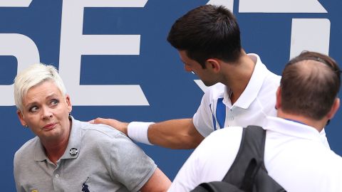 Djokovic tends to a line judge who was hit with the ball during his men's singles match against Pablo Carreno Busta at the US Open