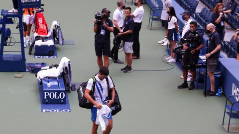 Novak Djokovic walks off court at the US Open after being defaulted.