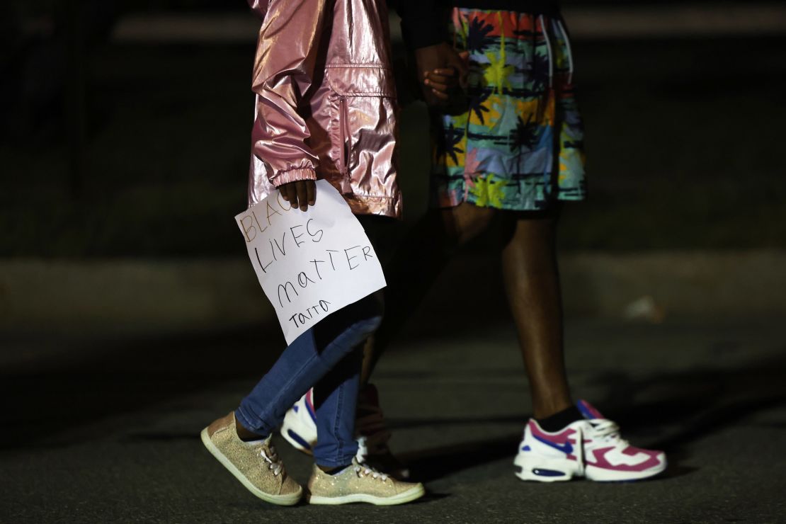 A child walks with a homemade sign in front of the Public Safety building after marching for Daniel Prude on September 06, 2020 in Rochester, New York.