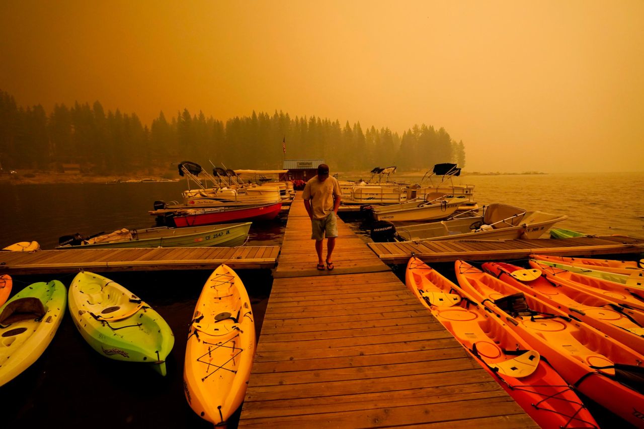 A business owner in Shaver Lake walks next to kayaks he rents as smoke from the Creek Fire fills the sky on September 6, 2020.