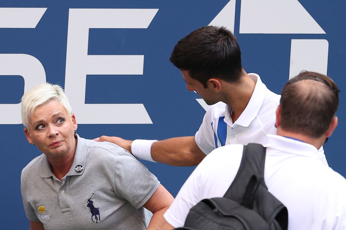 Novak Djokovic tends to a line judge who he hit with the ball.