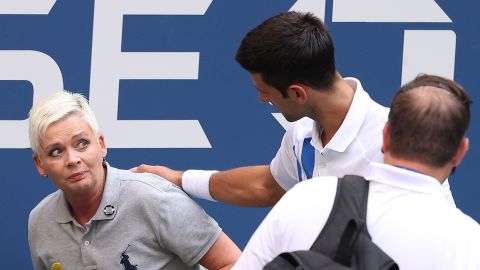 Novak Djokovic tends to a line judge who he hit with the ball.