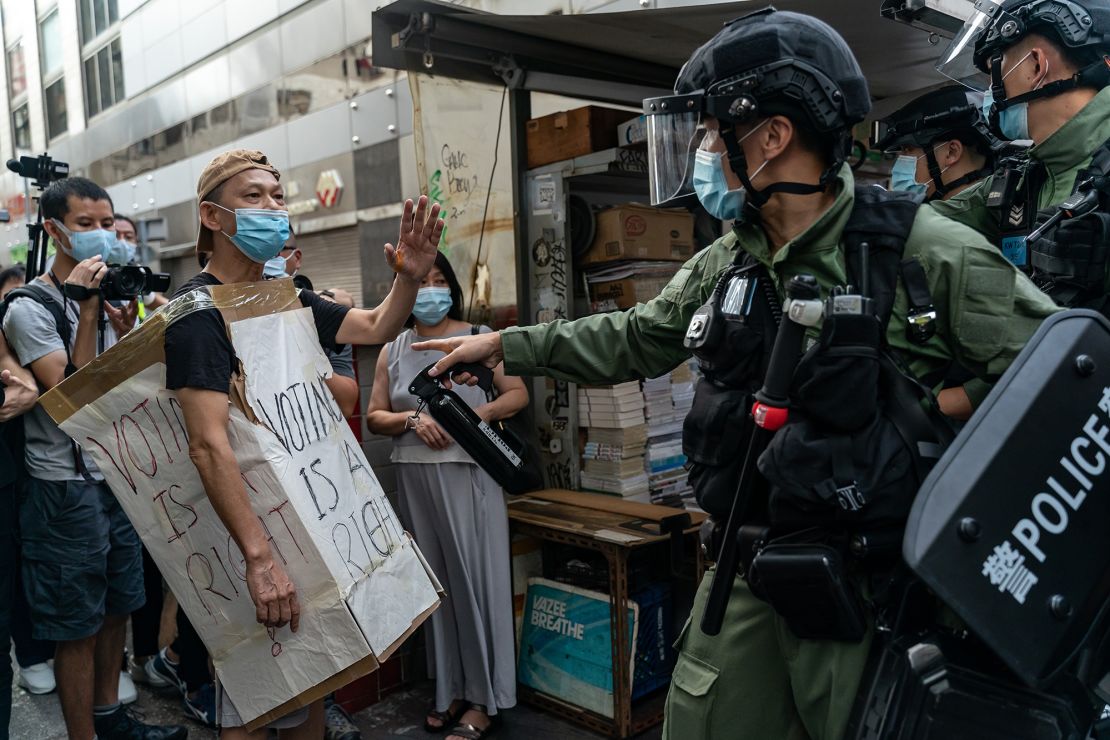 A man wearing a Voting Is A Right costome stand off with riot police during an anti-government protest on September 6, 2020 in Hong Kong, China.