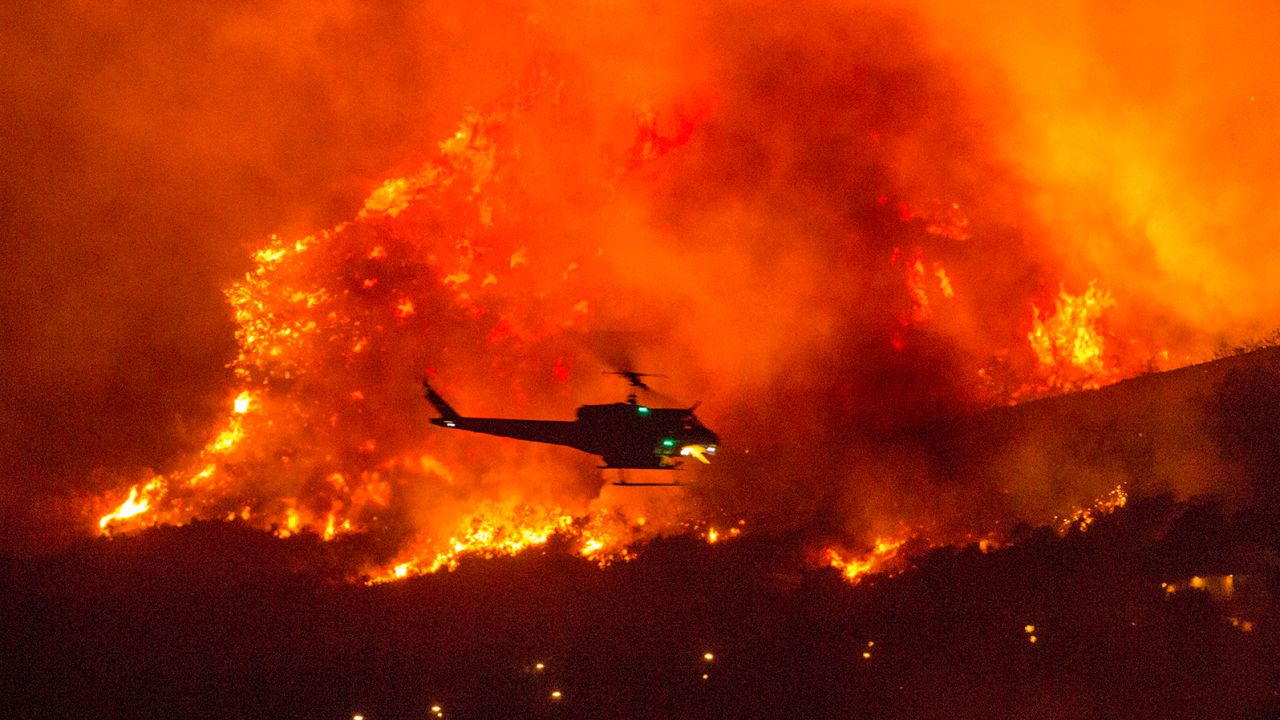 A helicopter prepares to drop water at a wildfire in Yucaipa, California, on September 5.