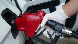 Dylan Stewart wears a rubber glove to pump gas at Costco Wholesale store gasoline station amid the global coronavirus COVID-19 pandemic, Friday, Aug. 21, 2020, in Burbank, Calif. (Photo by Kirby Lee/AP)