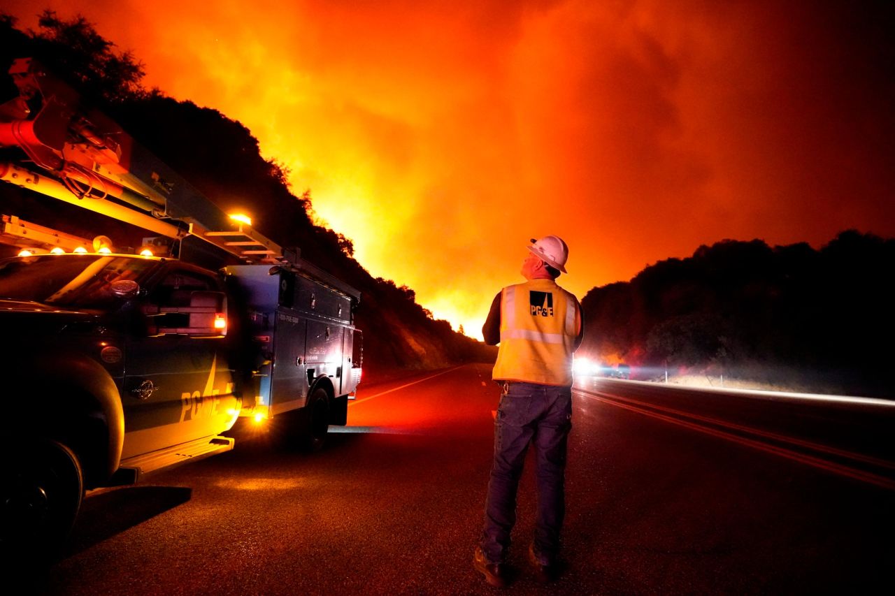A Pacific Gas and Electric worker looks up at the advancing Creek Fire near Alder Springs, California, on September 8.