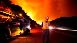 A Pacific Gas and Electric worker looks up at the advancing Creek Fire along Highway 168 Tuesday, Sept. 8, 2020, near Alder Springs, Calif. (AP Photo/Marcio Jose Sanchez)
