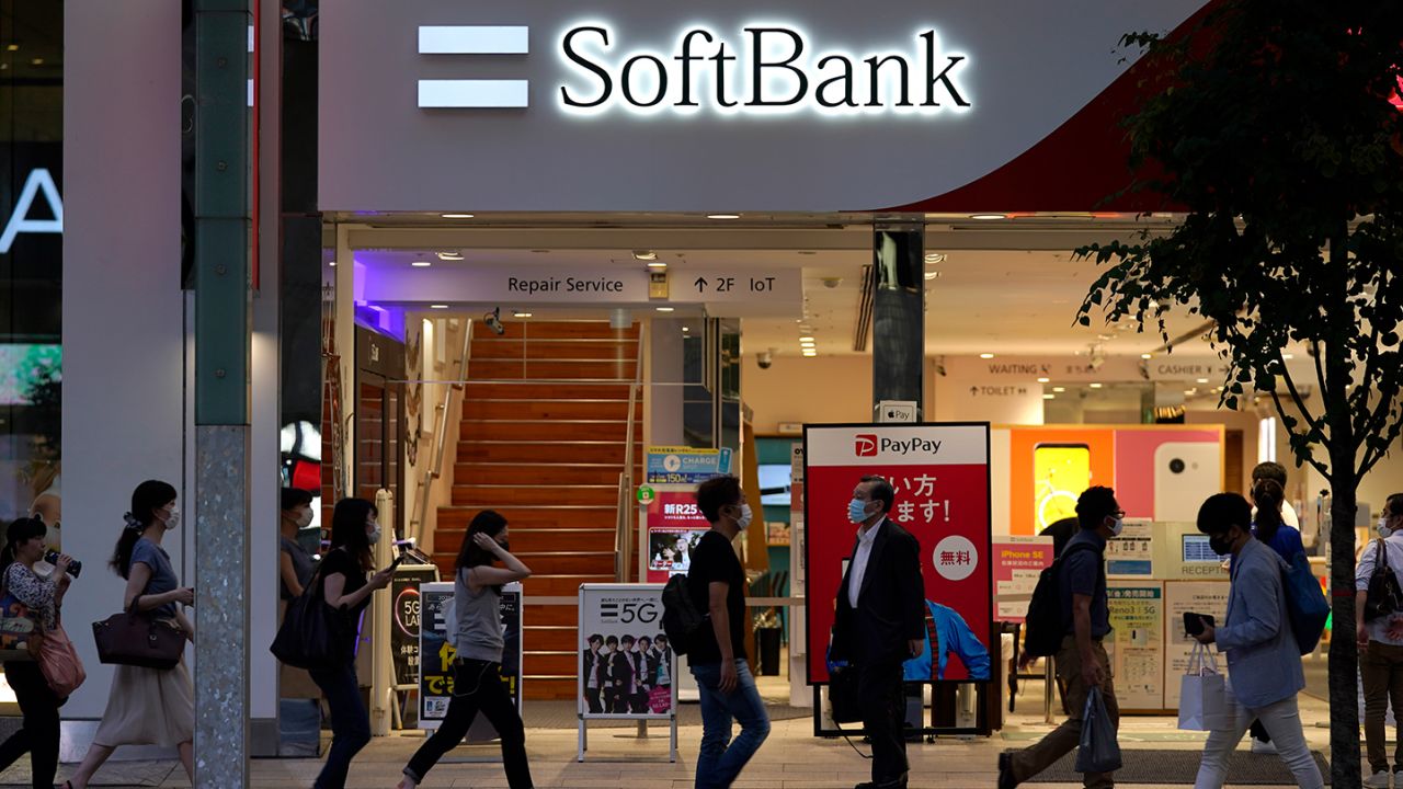 Pedestrians wearing protective masks walk past a SoftBank Corp. store in Tokyo, Japan, on Friday, Aug. 7, 2020. After reporting record losses in May and warning the coronavirus outbreak could be as devastating as the Great Depression,?SoftBank Group?founder?Masayoshi Son?is already poised to declare a recovery. Photographer: Toru Hanai/Bloomberg via Getty Images