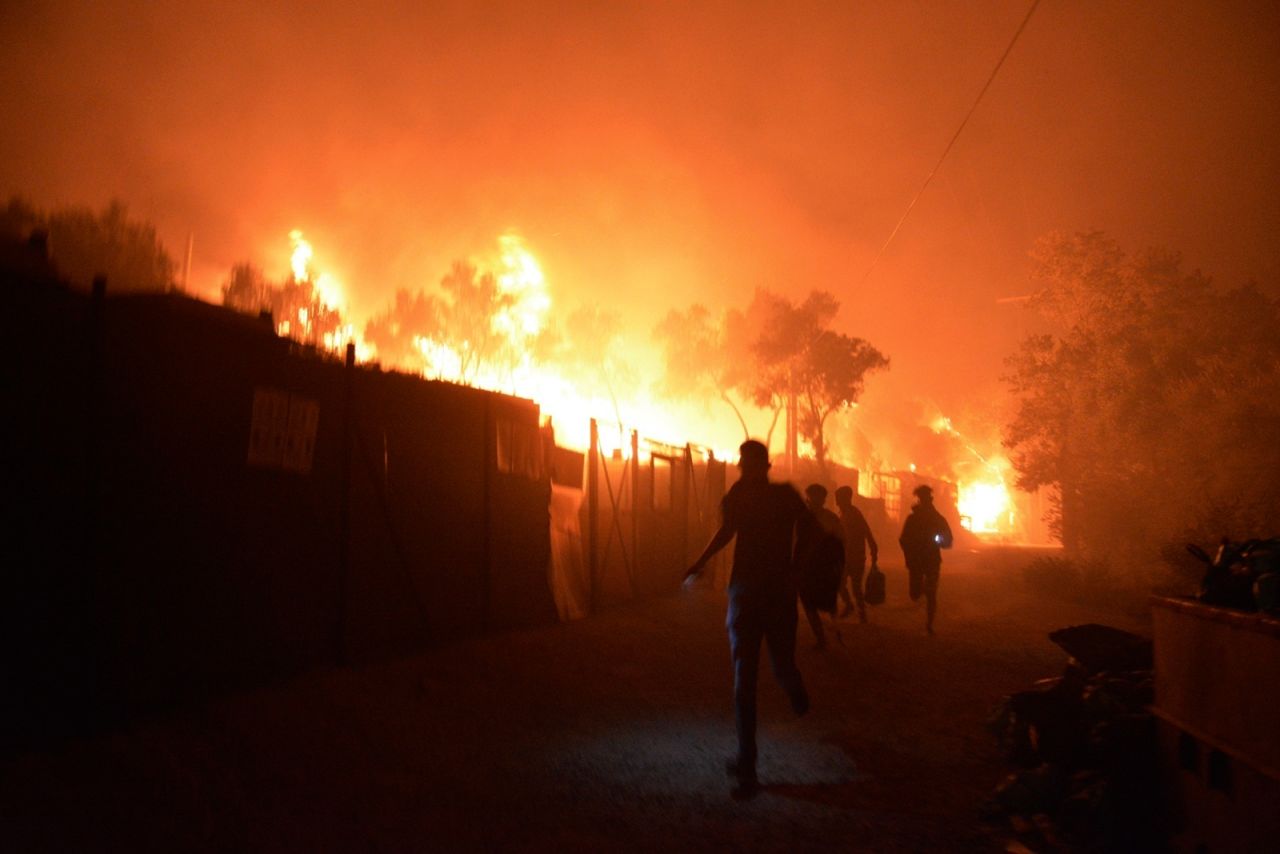 Refugees and migrants flee as the fire spreads through Moria.