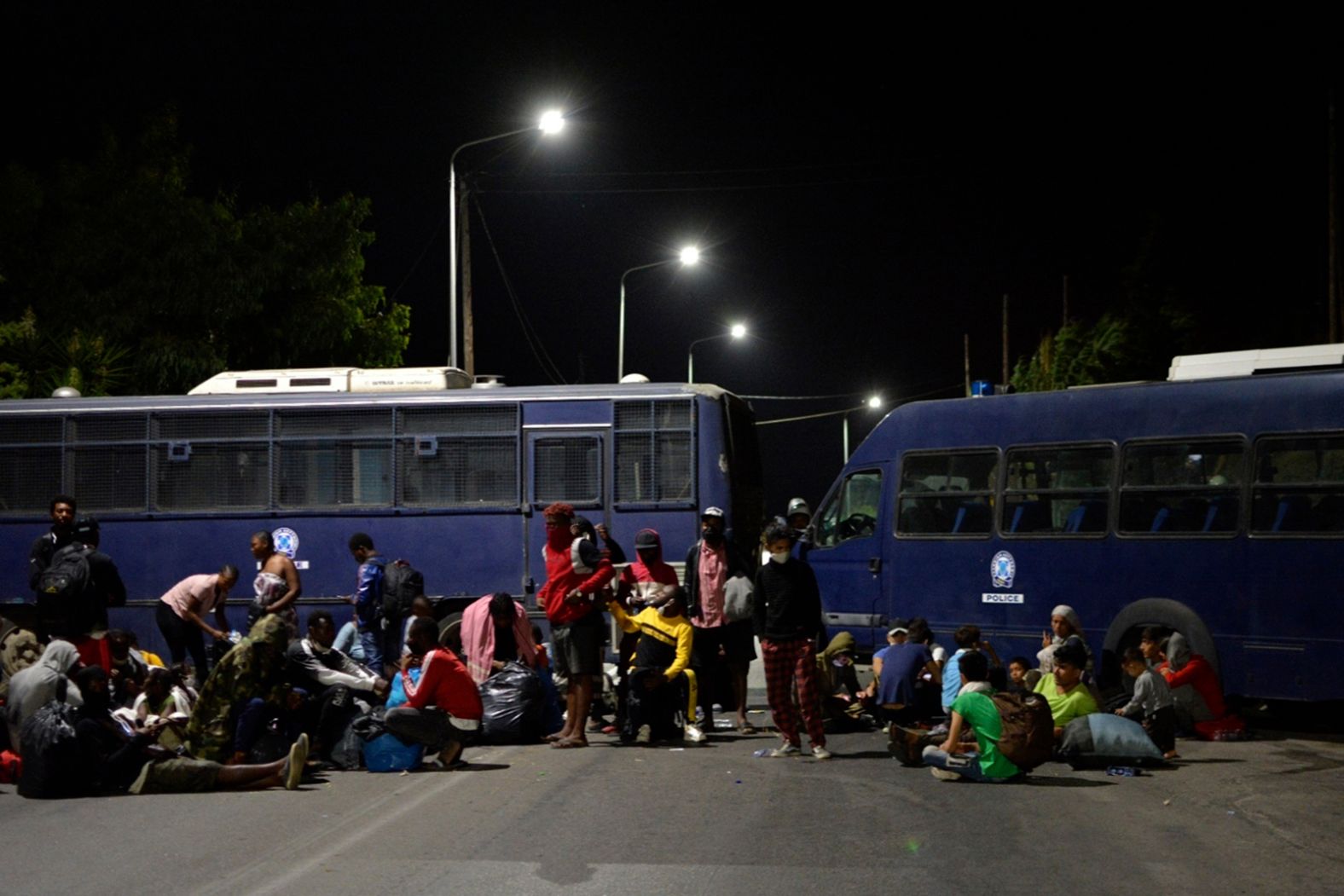 Camp evacuees try to reach the port of Mytilene as police block a road during the fire.