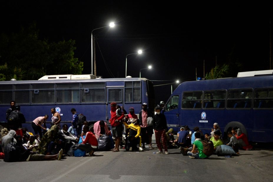 Camp evacuees try to reach the port of Mytilene as police block a road during the fire.