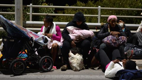 Refugees and migrants with their children gather on a bridge on Wednesday after the fire at the camp.