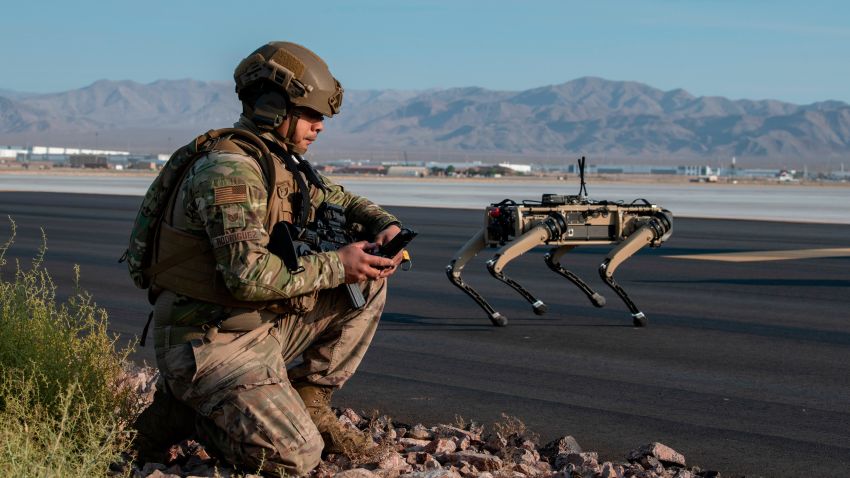 Tech. Sgt. John Rodiguez, 321st Contingency Response Squadron security team, provides security with a Ghost Robotics Vision 60 prototype at a simulated austere base during the Advanced Battle Management System exercise on Nellis Air Force Base, Nevada, Sept. 1, 2020. The ABMS is an interconnected battle network - the digital architecture or foundation - which collects, processes and shares data relevant to warfighters in order to make better decisions faster in the kill chain. In order to achieve all-domain superiority, it requires that individual military activities not simply be de-conflicted, but rather integrated -- activities in one domain must enhance the effectiveness of those in another domain. (U.S. Air Force photo by Tech. Sgt. Cory D. Payne)